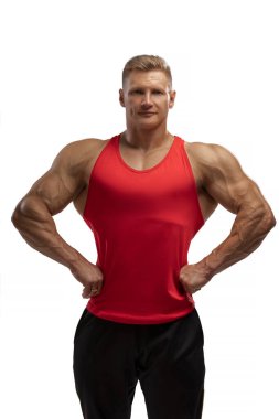 Portrait of an attractive athlete in a red tank top on a white cyclorama in the studio. Sports lifestyle.