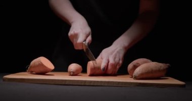 Bir kadın lezzetli bir akşam yemeği hazırlamak için tatlı patatesi adım adım öğütür. Alçakgönüllülük. Füzyon yiyecekler, sağlıklı yeme konsepti.