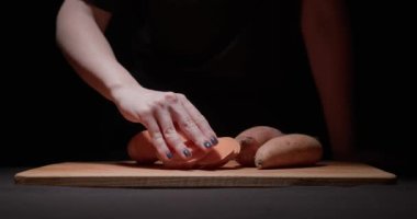 Bir kadın lezzetli bir akşam yemeği hazırlamak için tatlı patatesi adım adım öğütür. Odaklanma değişimleri, kamera hareketleri. Füzyon yiyecekler, sağlıklı yeme konsepti.