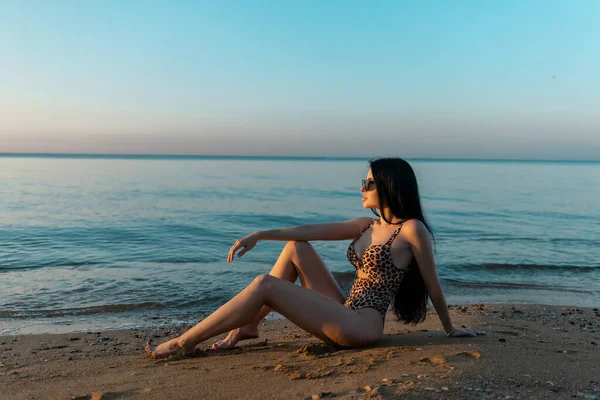 一个穿着豹子式单件泳衣的性感小女孩正在野外海滩度假 性感的女性身体 概念比基尼泳衣 — 图库照片