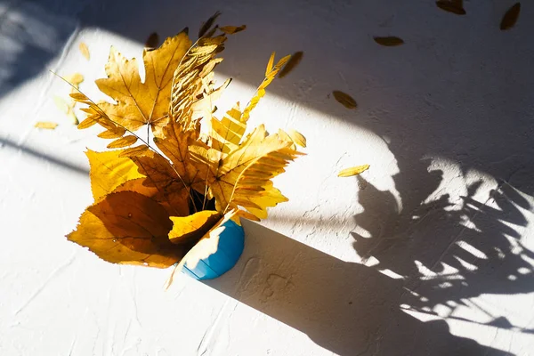 Flatlay autunno bianco sfondo bouquet giallo secco acero lasciare la luce dura — Foto Stock