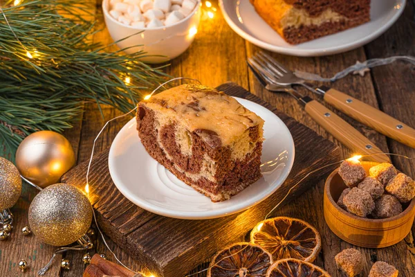 Pie on a festive background with pine branches and a burning garland. — Stock Photo, Image