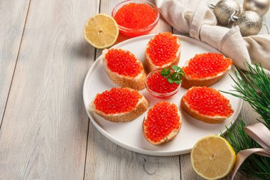 Hafif bir Noel arka planında kırmızı havyarlı sandviç..