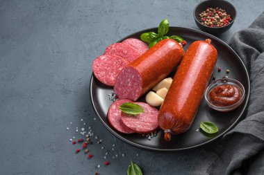 Fesleğenli sosis ve grafit arkaplanlı sarımsak. Kopyalanacak yer de var. Yan görünüm, yatay.