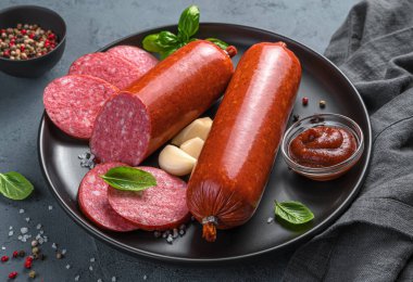 İçinde sosis, sarımsak, ketçap ve fesleğen olan bir tabak. Yan görünüm, yakın plan.