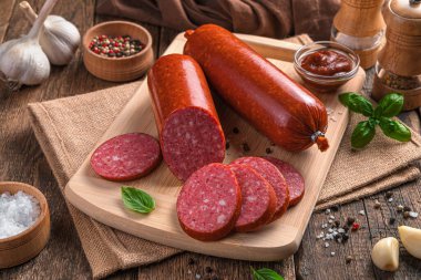 Kesme tahtasında baharatlı ve fesleğenli sosis..