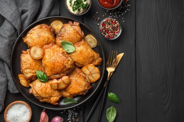 Kızarmış tavuk butları siyah tabakta yakın plan çekimde..