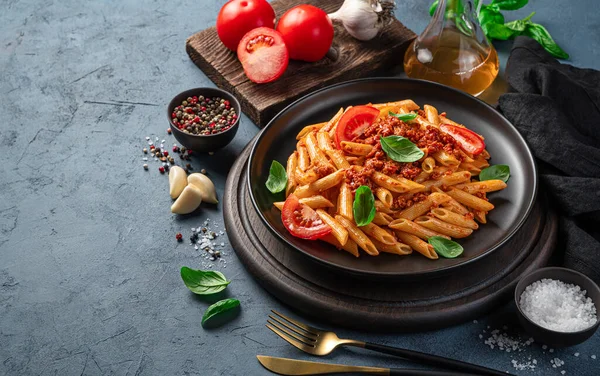 暗灰色の背景にボロネーゼソースと新鮮なトマトとバジルのパスタ 伝統的なイタリア料理 サイドビュー コピースペース — ストック写真