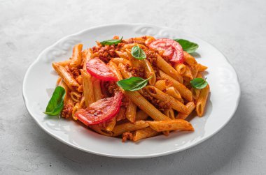 Gri arka planda bolonez soslu makarna. İtalyan mutfağı. Yan görünüm, yakın plan.