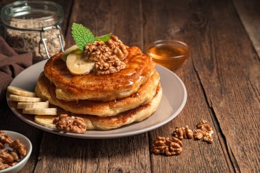 Ballı ve fındıklı ev yapımı krep ve ahşap zemin üzerinde muz. Yan görünüm, yatay.