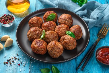 Mavi arka planda taze fesleğenli köfteler. Yan görünüm, yakın plan.