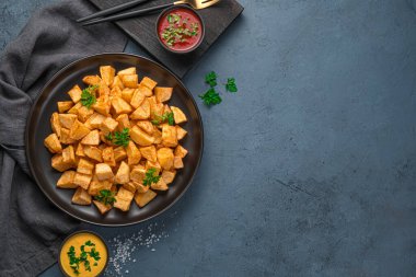 Grafit arka planda soslu patatas bravas ve kopyalayacak yer. Tapas, geleneksel İspanyol baharatlı aperatifi..