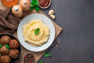 Koyu arkaplanda patates püresi ve köftelerle akşam yemeği. Üst görünüm, alanı kopyala.