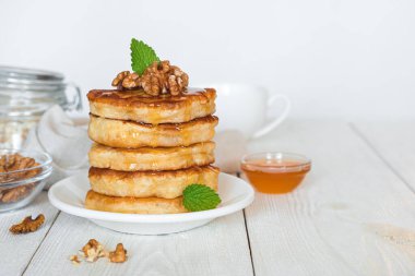 Ballı krep yığını, beyaz arka planda nane fıstığı. Yan görünüm, boşluk kopyala.