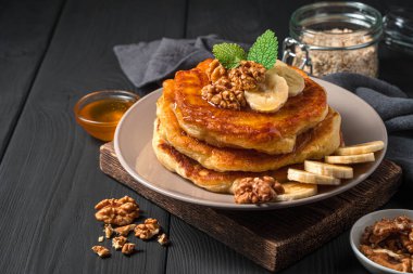 Siyah arka planda ballı, fındıklı ve muzlu krepler. Yan görünüm, boşluk kopyala.