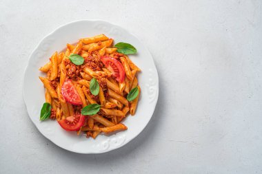 Gri arka planda beyaz bir tabakta bolonez soslu makarna ve kopyalayacak yer. Geleneksel İtalyan yemeği..