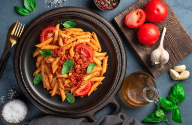 Bolonez soslu makarna ve grafit arkaplanlı malzemeler. Üst görünüm, yakın çekim.