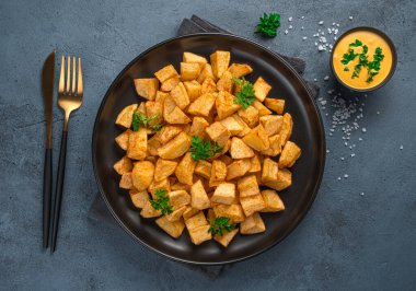 Soslu patatas bravas ve grafit arka planda taze maydanoz. Tapas, geleneksel İspanyol aperatifi..