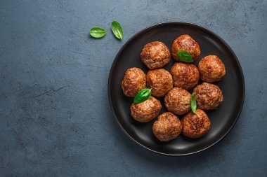 Arkaplanda siyah bir tabakta kızarmış köfte. Üst görünüm, alanı kopyala.