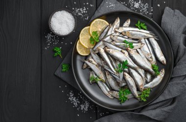 Siyah arka planda limon ve tuzlu sprey. Üst görünüm, alanı kopyala.
