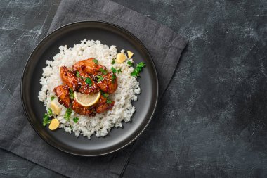 Teriyaki tavuğu, pilav, susam, zencefil ve koyu arkaplanda taze otlar. Üst görünüm, alanı kopyala.