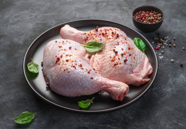 Koyu bir arka planda, yakın plan bir tabakta çiğ tavuk kaburgası..