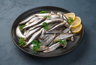 Limonlu ve maydanozlu bir tabak sardalya..
