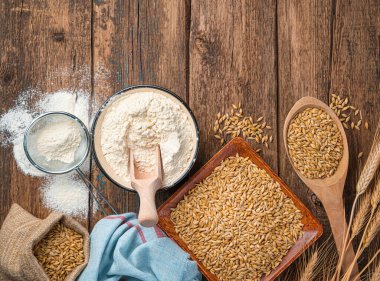 Tahta bir arka planda un, buğday ve dikenler..
