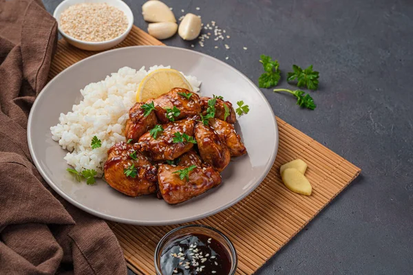Fried chicken breast with teriyaki sauce, served with sesame rice and lemon. — Stock Photo, Image