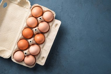 Koyu arkaplanda farklı paketlerdeki tavuk yumurtaları..