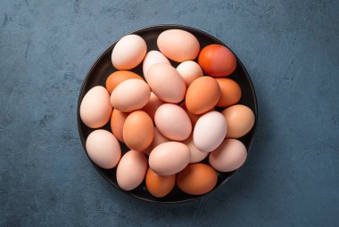 Koyu arkaplanda tabakta tavuk yumurtası..