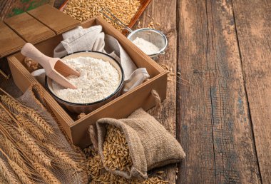 Tahta bir arka planda un, buğday ve buğday dikenleri.