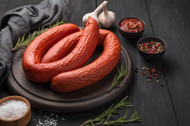 Baharat, sos ve biberiyeli füme sosis halkaları. Yan görünüm, boşluk kopyala.