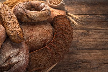 Ahşap arka planda çavdar ve buğday ekmeği çeşitleri. Yan görünüm, boşluk kopyala.