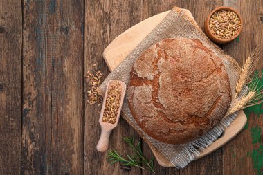 Ahşap arka planda bir somun çavdar ekmeği. Üst görünüm, alanı kopyala.