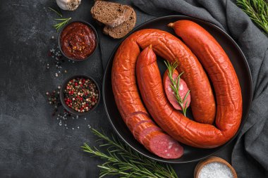 Baharatlı, biberiyeli ve baharatlı füme sosis halkası. Üst görünüm, alanı kopyala.