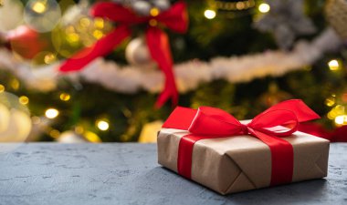 Noel ağacının arka planında bir hediye. Yan görüş, kopyalama alanı. Seçici odak.