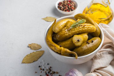 Gri arka planda salatalık turşusu ve biberli bir kase. Yan görünüm, boşluk kopyala.