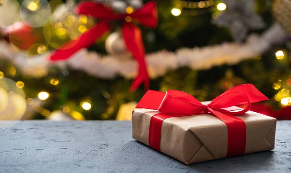 Noel ağacının arka planında bir hediye. Yan görüş, kopyalama alanı. Seçici odak.