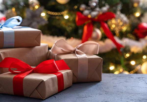 クリスマスツリーの背景に異なるリボンを持つ贈り物 サイドビュー コピースペース — ストック写真