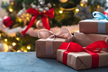 Süslü bir Noel ağacının arka planında hediyeler. Yan görüş, kopyalama alanı. Seçici odak.