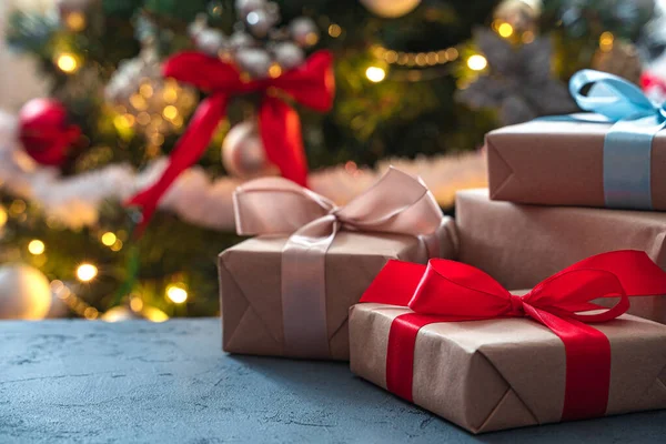 Süslü bir Noel ağacının arka planında hediyeler. Yan görüş, kopyalama alanı. Seçici odak.