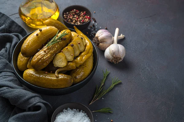 Arka planda biberiye ve biberiyeli salatalık turşusu. Yan görünüm, boşluk kopyala.