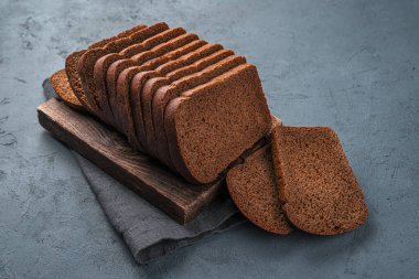 Taze çavdar ekmeği grafit arka planda parçalara ayrılmış. Yan görünüm.