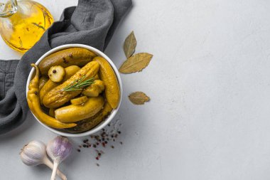 Gri arka planda gevrek, salatalık turşusu, sarımsak ve defne yaprağı. Üst görünüm, boşluğu kopyala. Ev yapımı turşu..