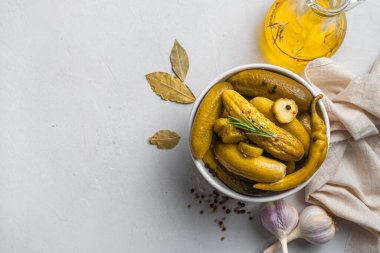 Gri arka planda gevrek, salatalık turşusu, tereyağı ve defne yaprağı. Üst görünüm, alanı kopyala.