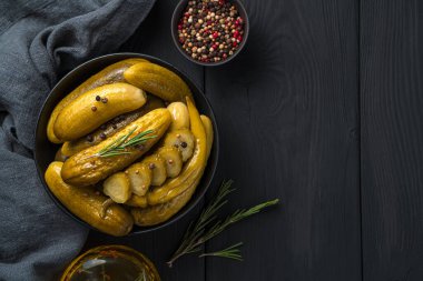 Ahşap bir arka planda biber ve biberiyeli salatalık turşusu. Üst görünüm, alanı kopyala.