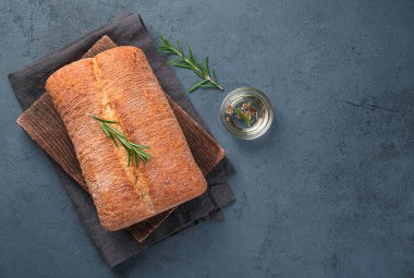 Taze, çıtır ciabatta zeytinyağlı ve biberiyeli grafit arka planda. Üst görünüm, alanı kopyala.