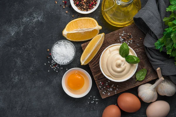 Mayonez, ve pişirmek için malzemeler: siyah arka planda yumurta, limon ve tereyağı. Ev yapımı mayonez. Üst görünüm.