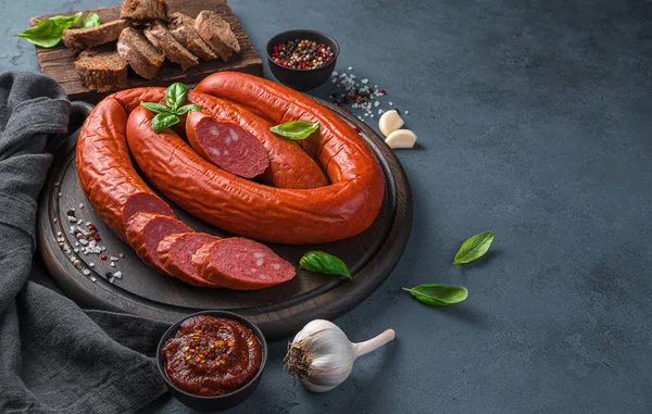 Fesleğenli füme sosis ve koyu arkaplanda sarımsak. Yan görünüm, boşluk kopyala